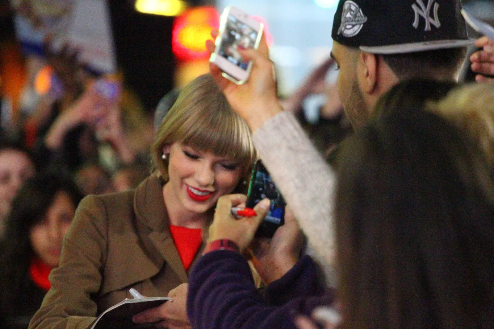 Taylor Swift เซ็นลายเซ็นให้แฟนเพลงในวันเปิดตัวอัลบั้ม Red ที่รายการ Good Morning America ปี 2012