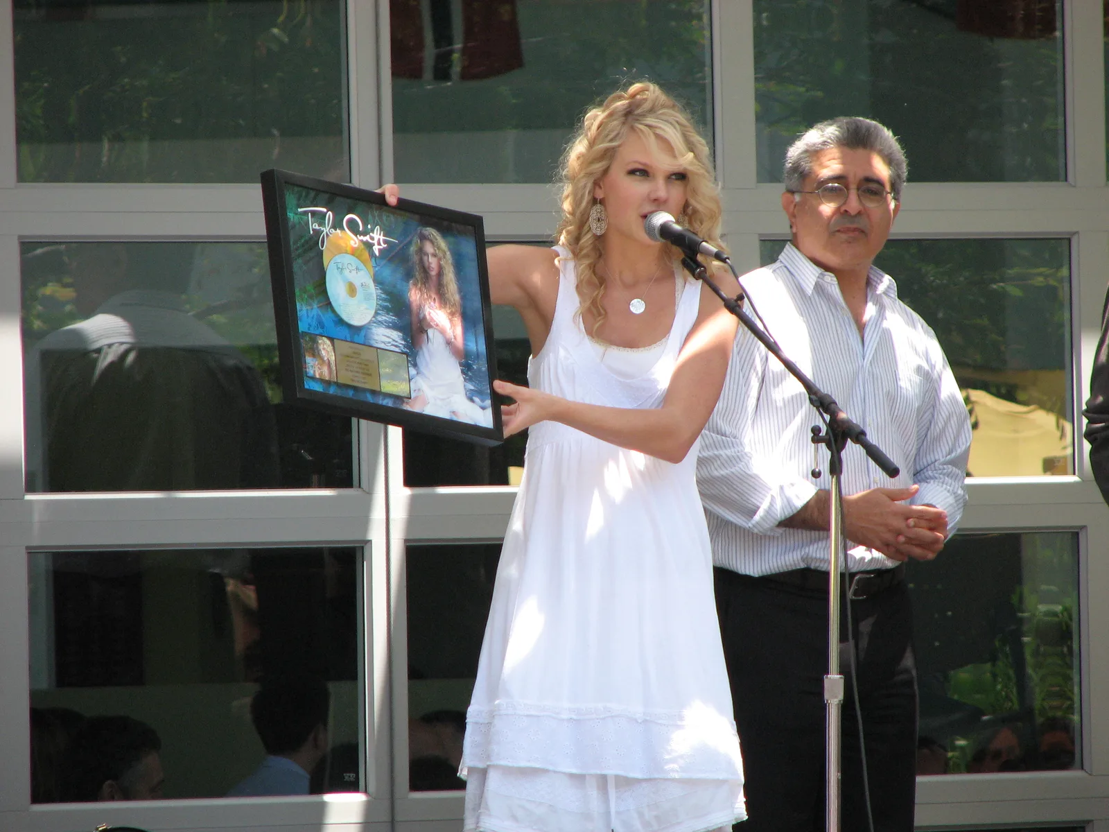 Taylor Swift อัลบั้มแรก 20 ปี: Taylor Swift ถือกรอบรูปที่มีปกอัลบั้มแรกระหว่างโปรโมตอัลบั้มที่ Yahoo เมื่อ 16 พฤษภาคม 2007