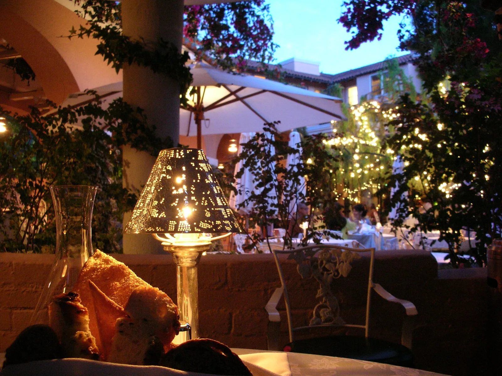 ห้องอาหาร Polo Lounge ในโรงแรม The Beverly Hills Hotel ยามค่ำ มีโคมไฟบนโต๊ะและไฟประดับต้นไม้ ภาพวันที่ 10 กรกฎาคม 2009