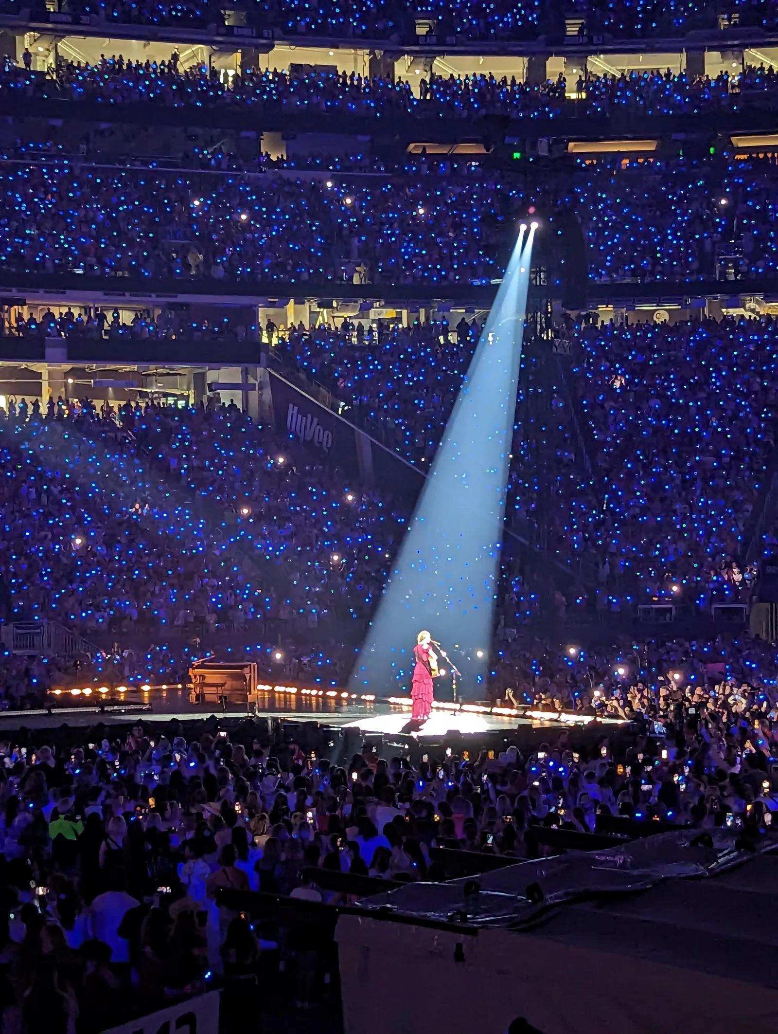 Taylor Swift ยืนเล่นกีตาร์ใต้แสงสปอตไลต์ในช่วงเพลงอะคูสติกของ The Eras Tour ที่มินนีแอโพลิส 24 มิถุนายน 2023 ท่ามกลางผู้ชมเต็มสนาม