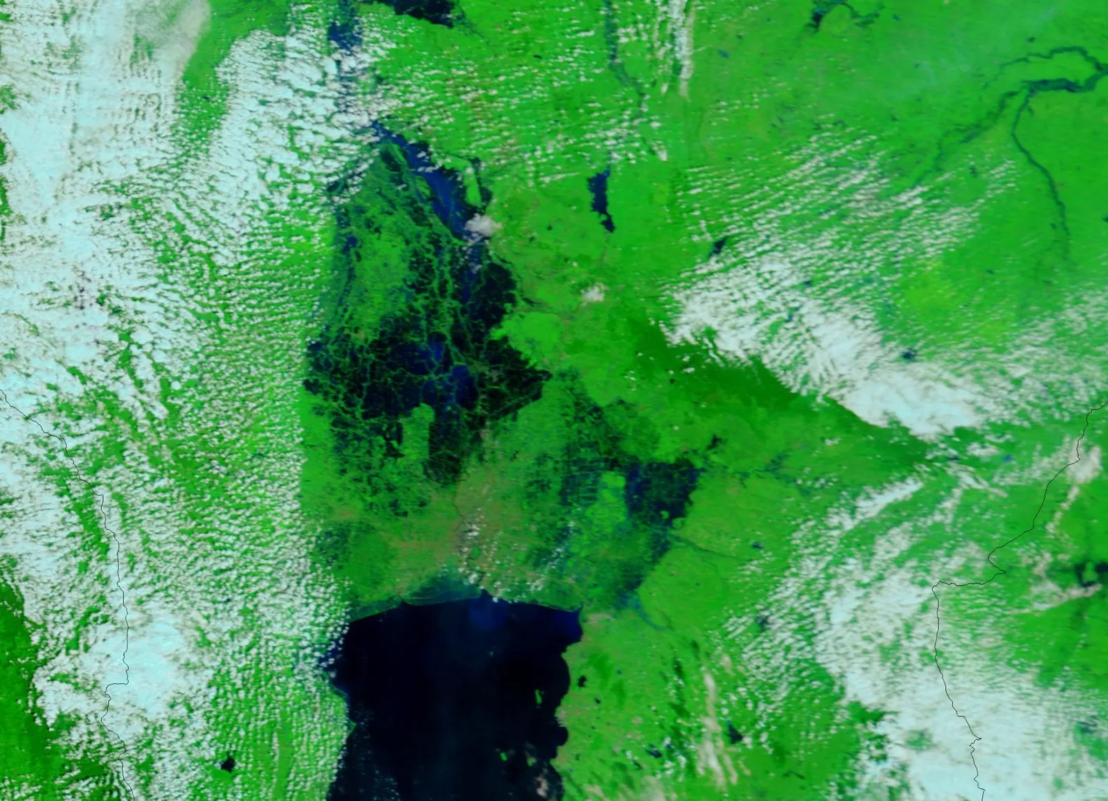 ภาพสีผสมจากเครื่อง MODIS บนดาวเทียม Terra ของ NASA วันที่ 19 ตุลาคม 2554 ตัดเฉพาะภาคกลางของไทย น้ำซึ่งแสดงเป็นสีน้ำเงินเข้มถึงดำปกคลุมที่ราบลุ่มเหนืออ่าวไทยระหว่างน้ำท่วม 2554 พืชพรรณเป็นสีเขียวและเมฆเป็นสีฟ้าอ่อน