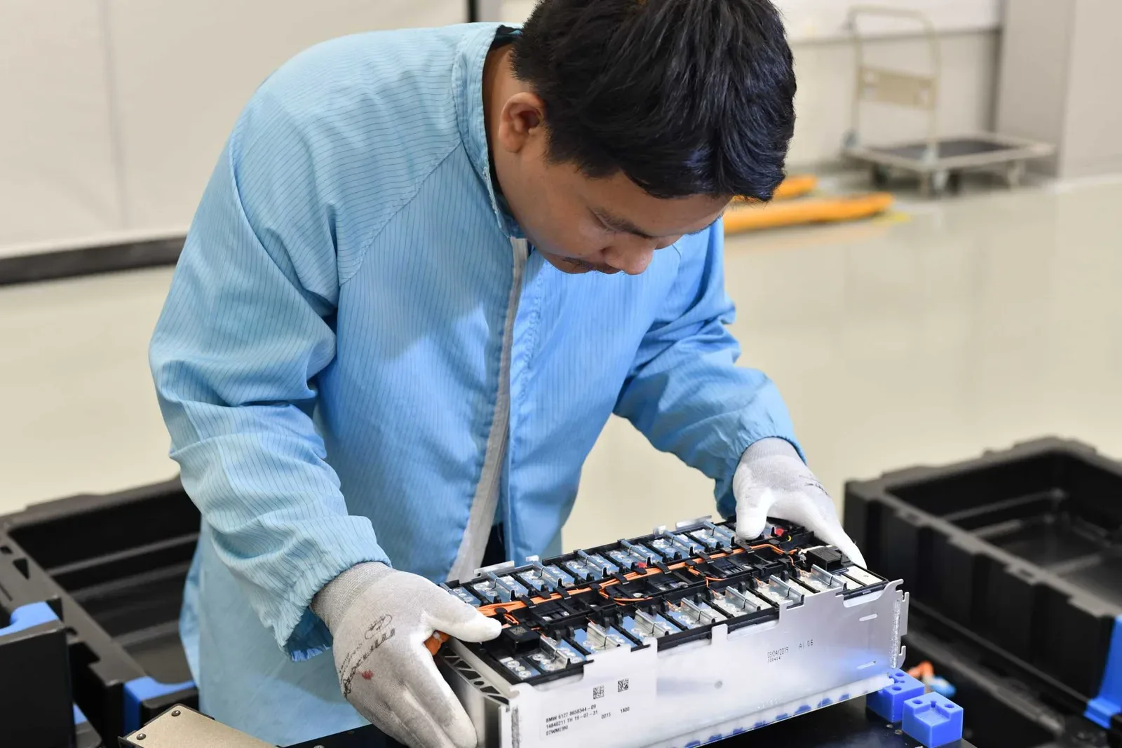 พนักงานสวมถุงมือประกอบโมดูลแบตเตอรี่แรงดันสูงที่โรงงาน Dräxlmaier ซึ่งผลิตแบตเตอรี่ให้โรงงาน BMW Group ในไทย ปี 2019