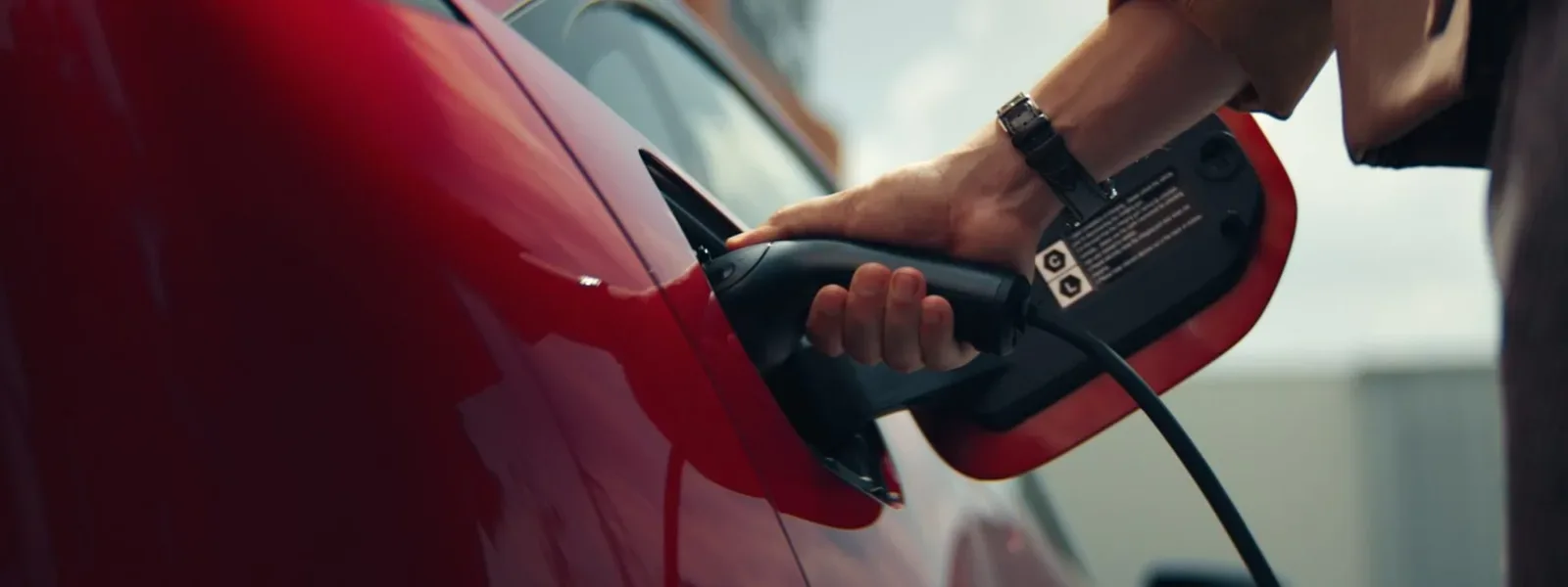 มือเสียบหัวชาร์จเข้าช่องชาร์จของ Mazda6e สีแดง