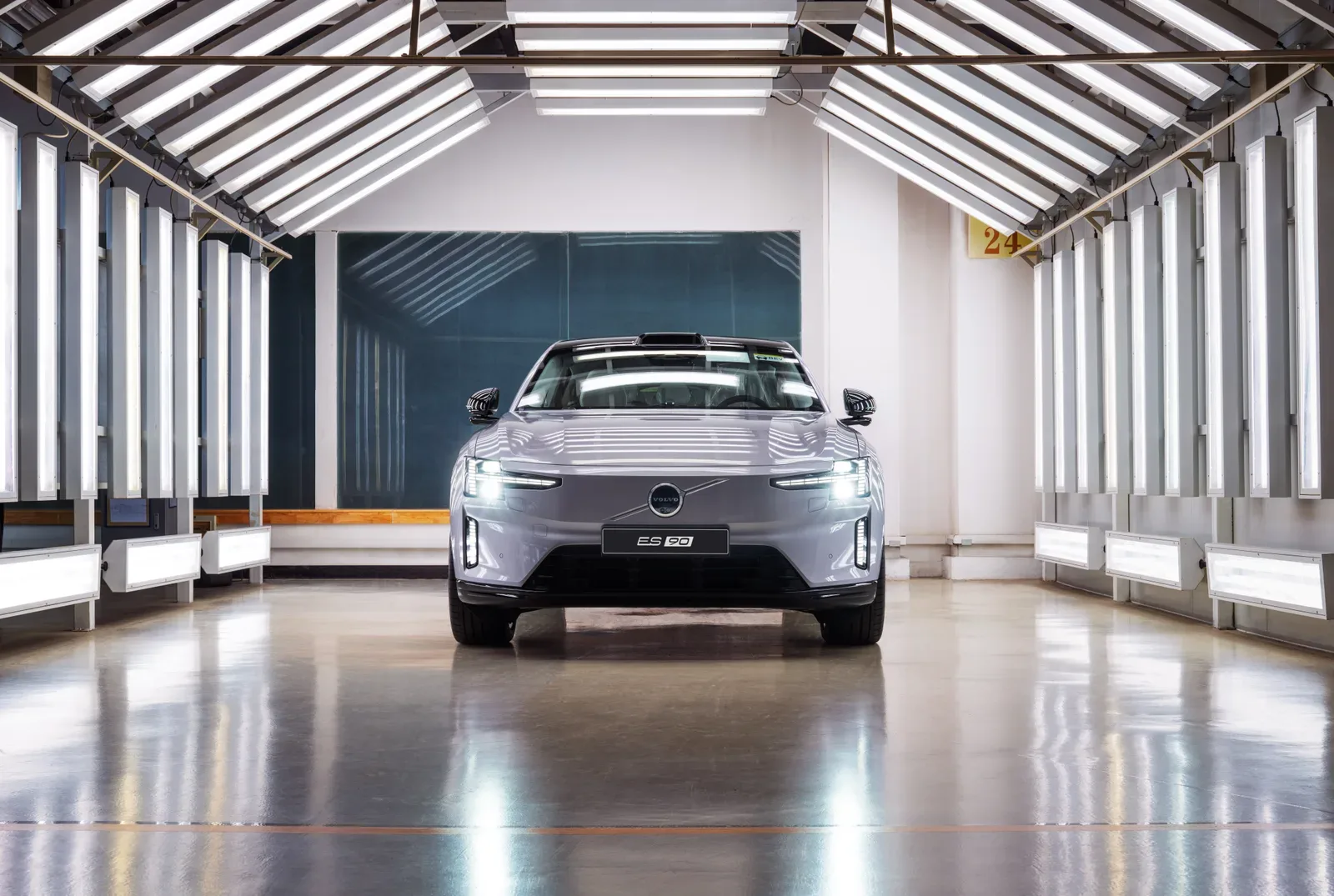 Volvo ES90 สีเงินจอดในอุโมงค์ไฟตรวจสภาพรถของโรงงาน Volvo Cars