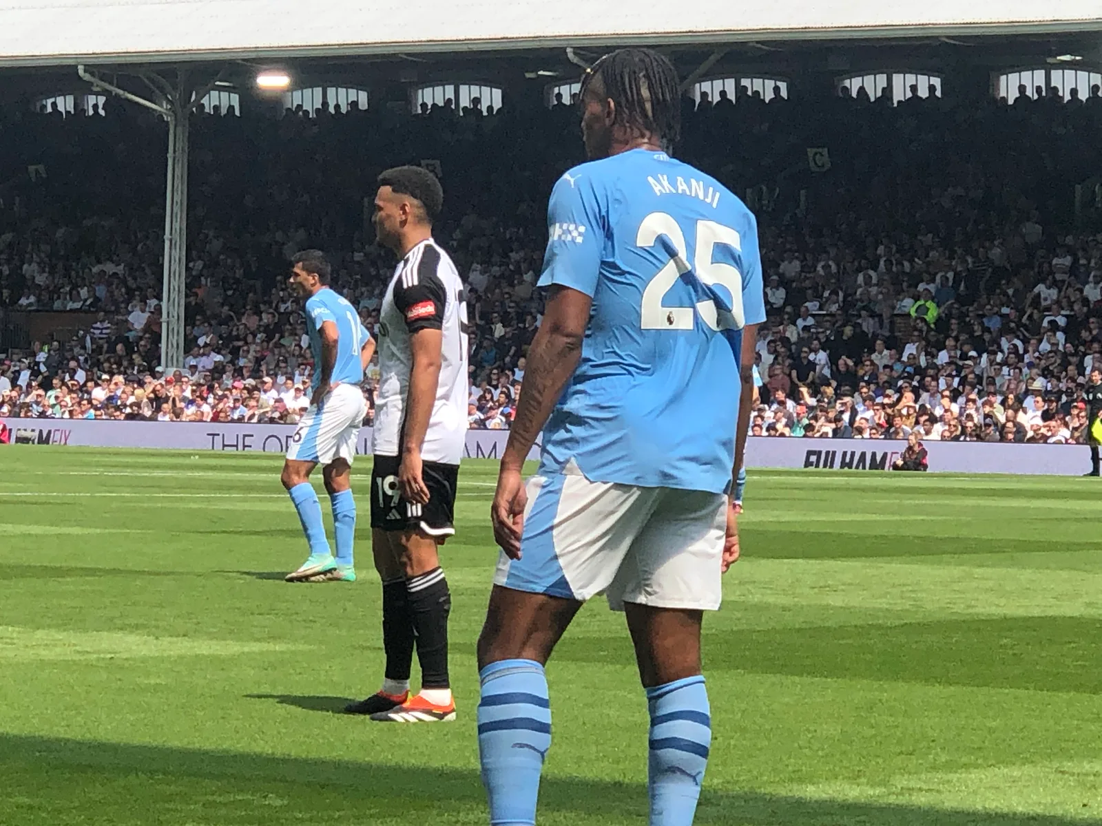 นักเตะ Manchester City หมายเลข 25 ชื่อ AKANJI สวมชุดแข่งเหย้า เสื้อสีฟ้าอ่อน กางเกงขาสั้นสีขาวแถบฟ้า ถุงเท้าสีฟ้าคาดแถบกรมท่า ในเกมกับ Fulham เมื่อ 11 พฤษภาคม 2024