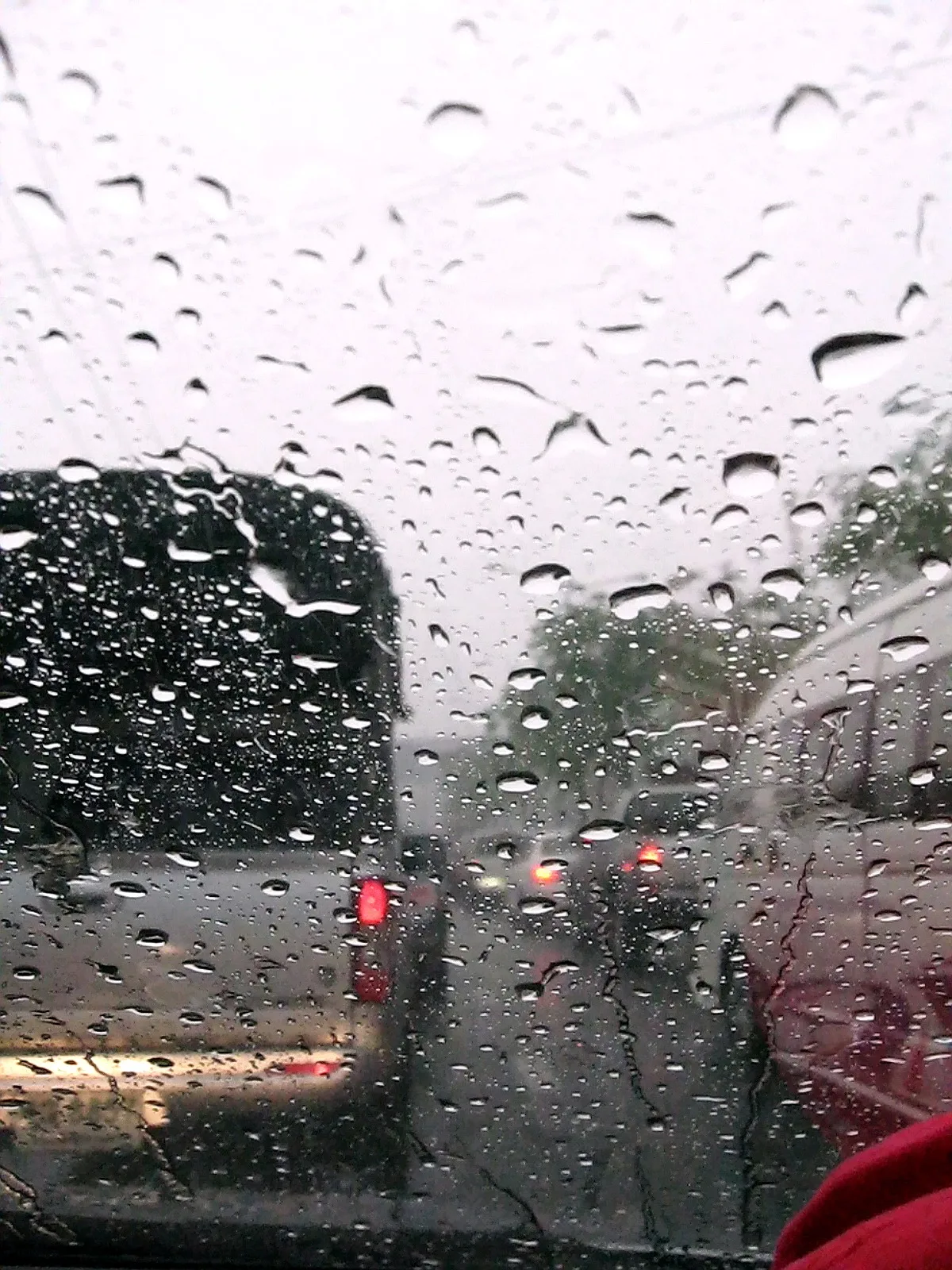 รถติดบนถนนในกรุงเทพฯ ขณะฝนตก มองผ่านกระจกรถที่มีหยดน้ำ