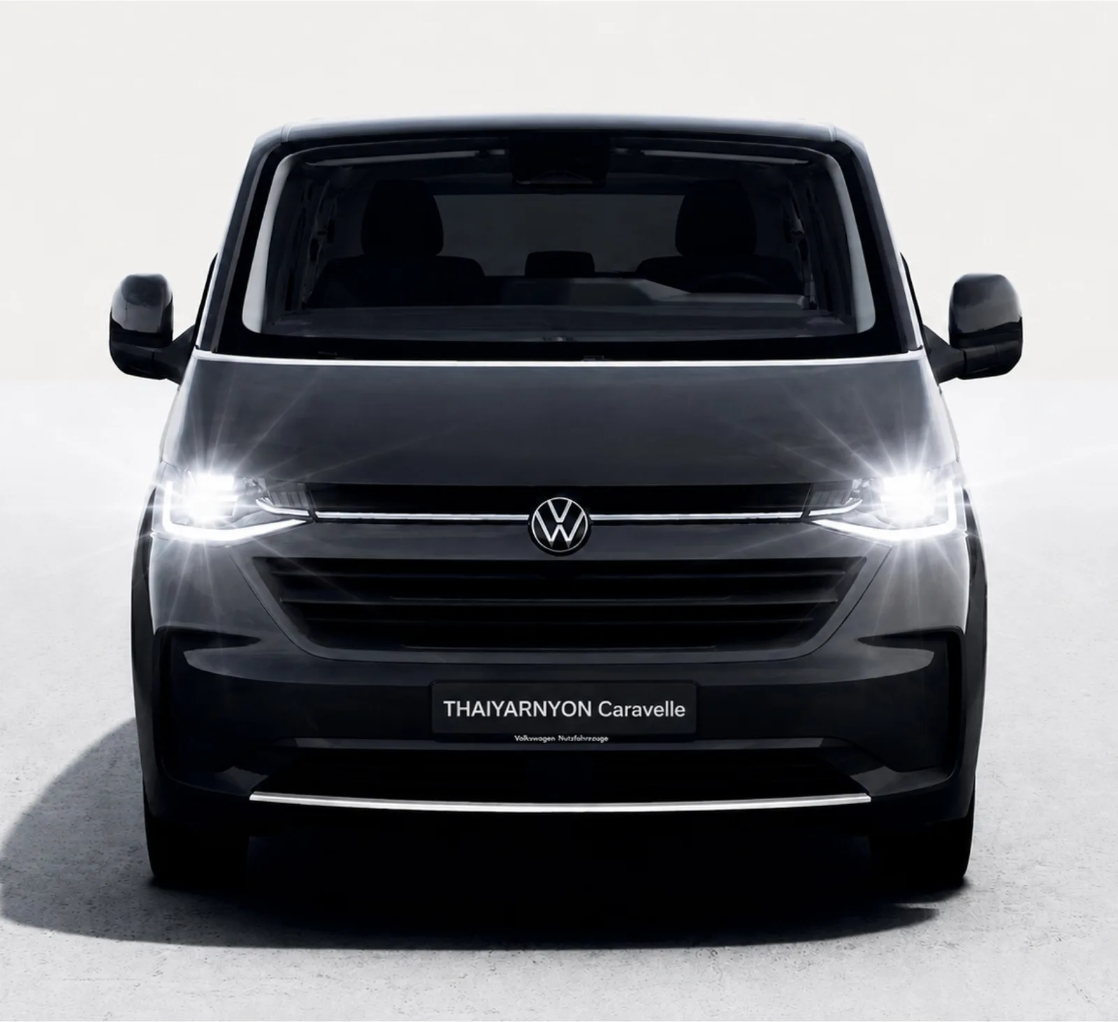 ด้านหน้าของ Thaiyarnyon Caravelle T7 สีดำ ไฟหน้า LED เปิดอยู่ ป้ายหน้ารถเขียน THAIYARNYON Caravelle ภาพจากปกโบรชัวร์