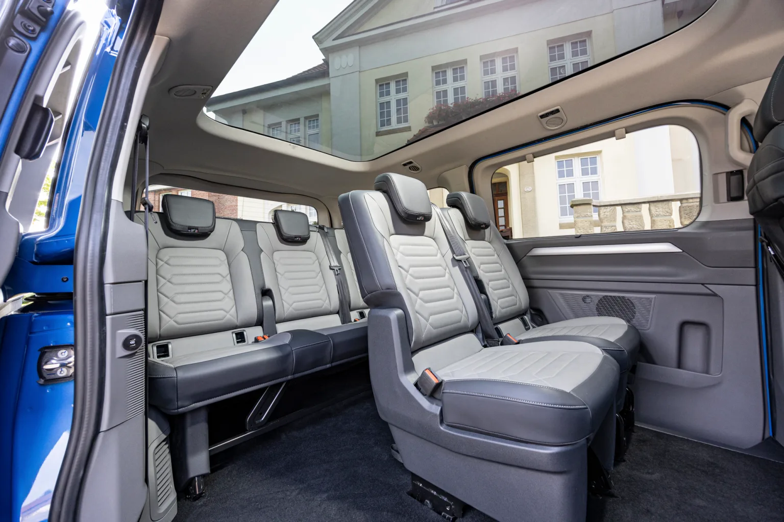 ห้องโดยสารของ Caravelle รุ่นใหม่ปี 2024 เบาะแยกสีเทาพร้อมที่วางแขน เบาะยาวแถวหลัง และหลังคาพาโนรามา