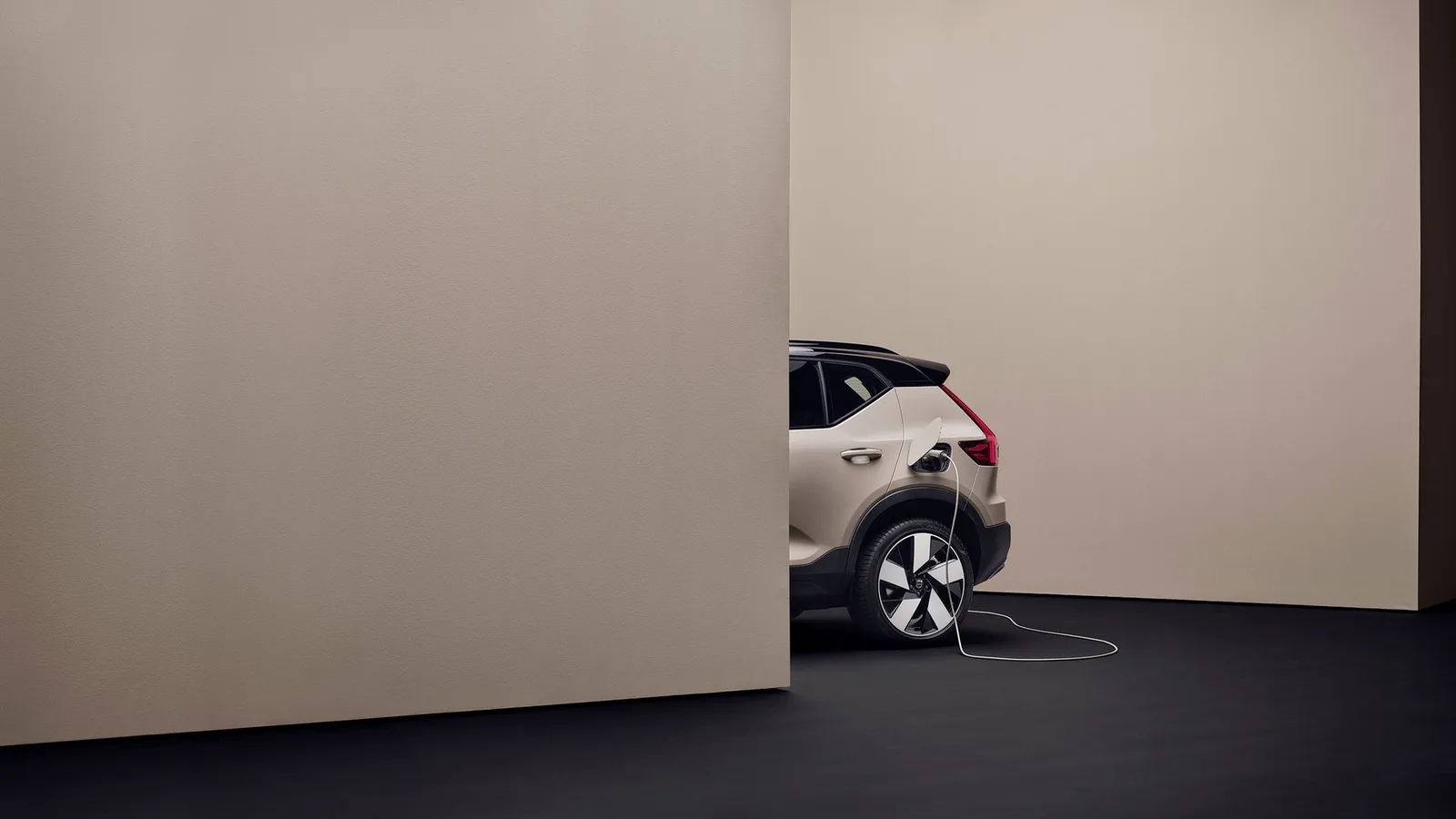 Volvo EX40 สีเบจเสียบสายชาร์จที่ช่องชาร์จด้านหลัง ภาพจากหน้ารุ่นของ Volvo ประเทศไทย