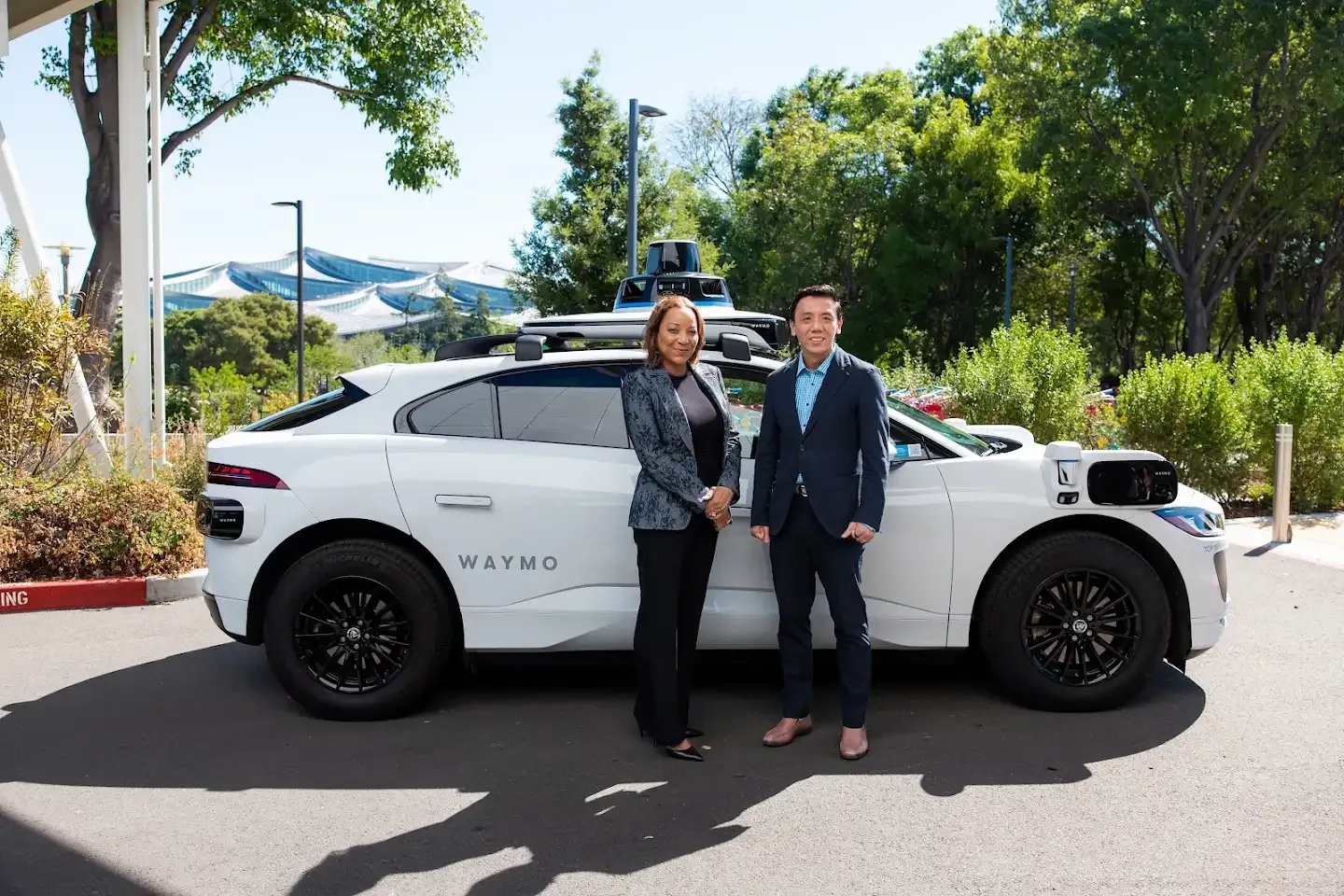 ทเคดรา มาวากานา ซีอีโอร่วมของ Waymo และเจฟฟรีย์ ซิว รัฐมนตรีคมนาคมสิงคโปร์ ยืนข้างรถ Jaguar I-PACE ของ Waymo