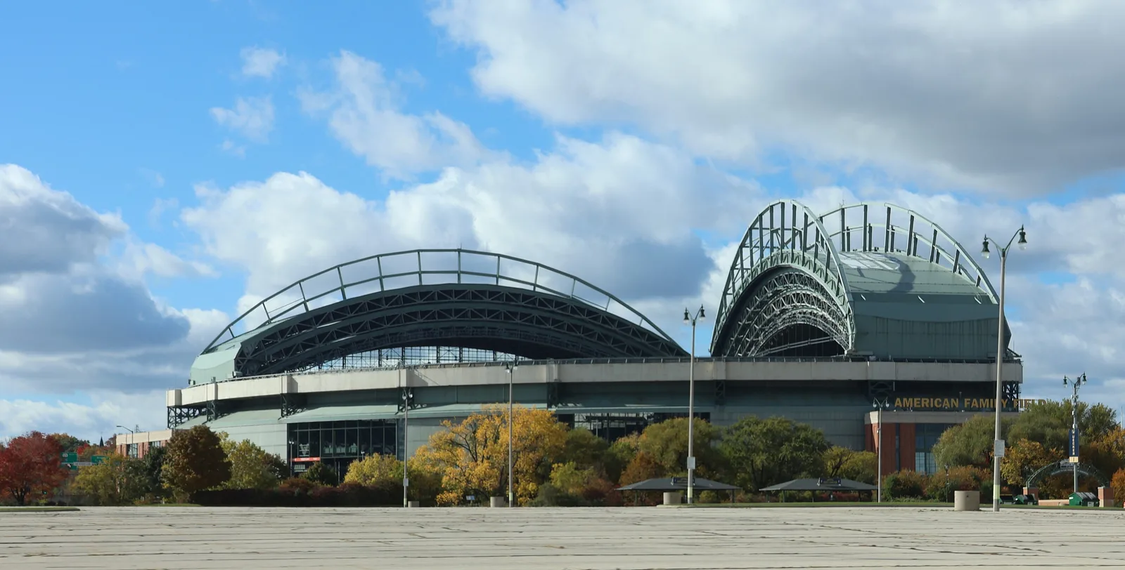 ด้านนอก American Family Field สนามเหย้าของ Milwaukee Brewers ที่มีหลังคาโค้ง ใต้ท้องฟ้าสีฟ้า ภาพถ่ายเดือนตุลาคม 2023