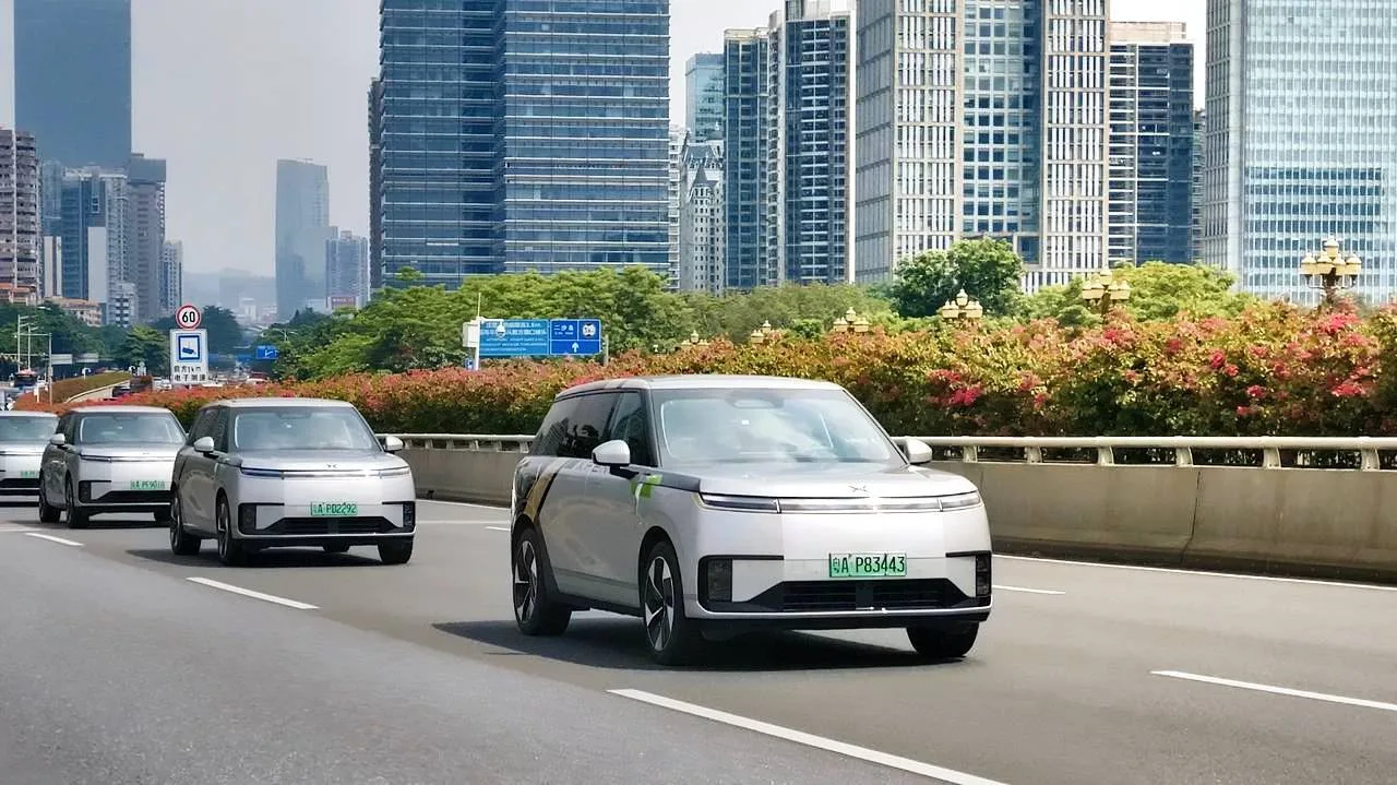 ขบวนรถ Robotaxi ของ XPENG ซึ่งให้บริการภายใต้ชื่อ XPENG YOYO หลายคันวิ่งบนถนนในเมืองที่มีอาคารสูง