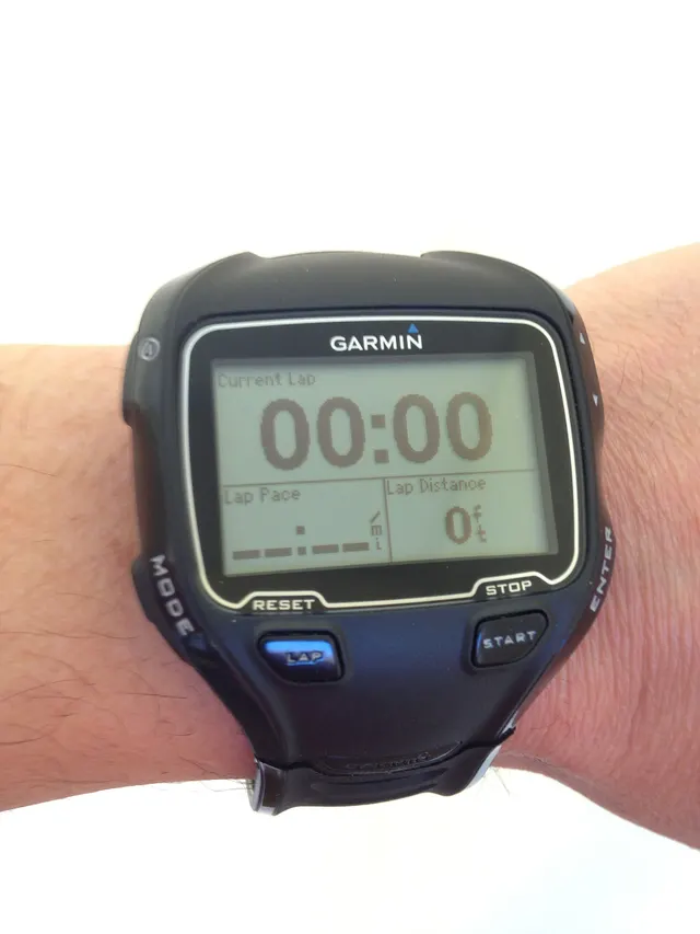 นาฬิกา GPS สีดำสวมที่ข้อมือ หน้าจอแสดงเวลารอบปัจจุบัน 00:00 ความเร็วต่อรอบและระยะทางต่อรอบ มีปุ่มเริ่มและหยุด